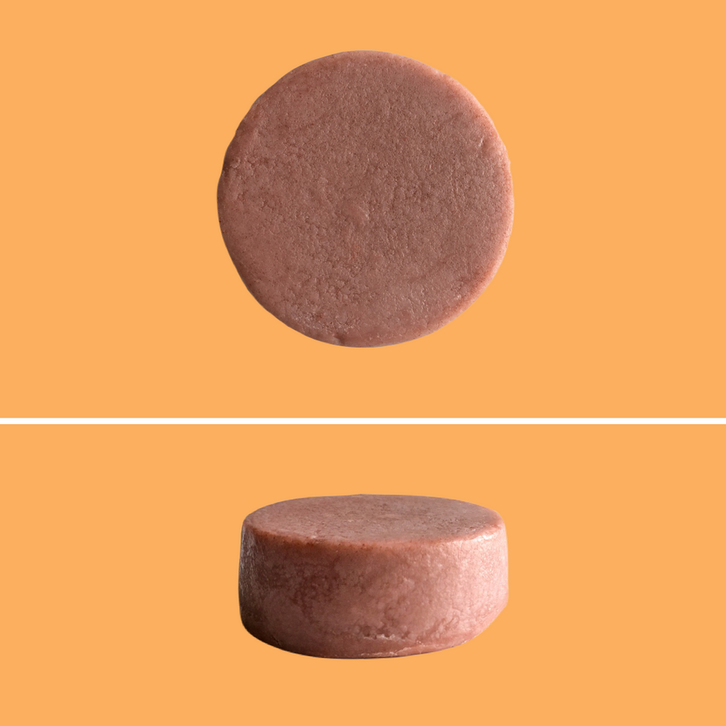 Top and side view of Green Ablutions Moroccan Argan Oil Conditioner Bar on orange background. Sustainable Zero-waste Plastic-free haircare.
